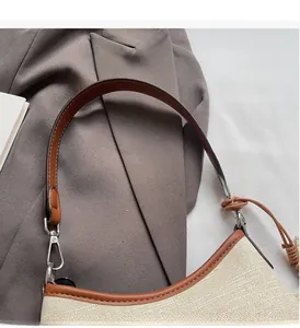 Detail of canvas texture and brown leather trim on a stylish bucket bag with metal buckle