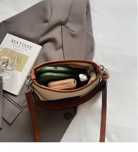 Detailed interior of a beige canvas shoulder bag showing large capacity for phone and wallet