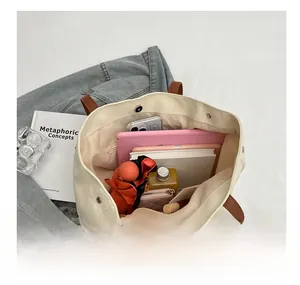 Detailed interior view of a large canvas tote bag showing storage for a tablet and umbrella