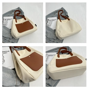 Detail view of large canvas tote bag with brown leather pocket and metal buckle detail