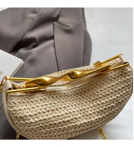 Detail of a beige woven handbag featuring a luxurious gold twisted metal handle and hardware