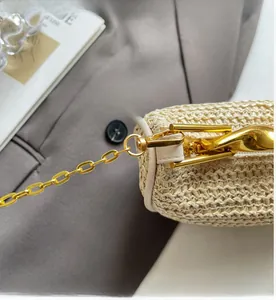 Close-up of woven handbag texture with golden chain links and durable metal hooks
