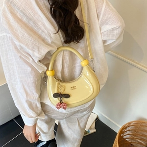 Borsa a mezzaluna giallo vivace minimalista con ciondolo a ciliegia e trama in pelle