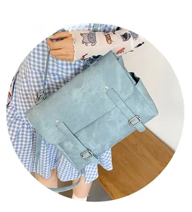 Dettaglio della borsa a tracolla azzurra con trama scamosciata e fibbie decorative