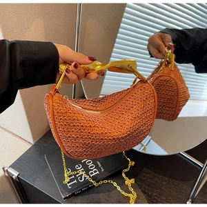 Detail of orange woven saddle bag featuring a unique gold metal handle and chain strap