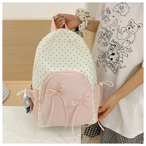 Close-up of pink bow accents and polka dot patterns on a stylish student backpack