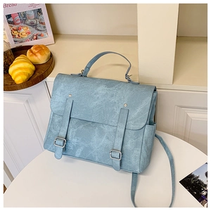 Dettaglio della borsa a tracolla vintage azzurra con cinghie decorative e texture liscia
