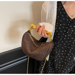 Detail of a brown woven hobo bag featuring a distinctive gold sardine-style metal handle