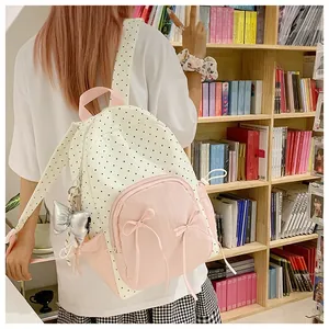 Detail of Korean style polka dot backpack with a pink bow pocket and silver metal charm