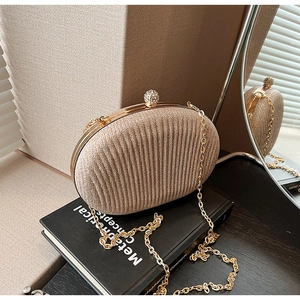 Detailed shot of champagne gold glitter evening clutch with diamond-encrusted ball clasp