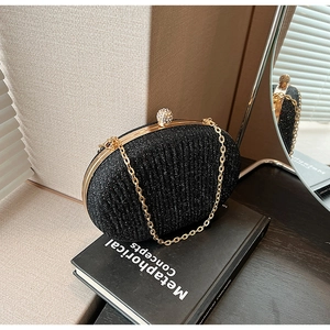 Detail view of black glitter evening clutch with gold metal frame and ball clasp