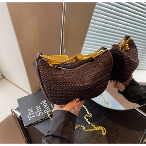 Detail of dark brown woven crescent bag with gold twisted metal handle and chain strap