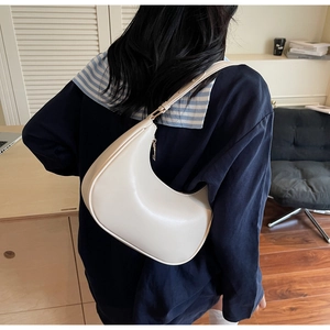 Model view of ivory crescent hobo bag showing adjustable strap and smooth leather texture