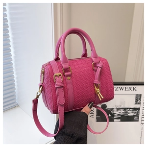 Macro shot of rose pink woven leather crossbody bag with golden metal zipper and straps