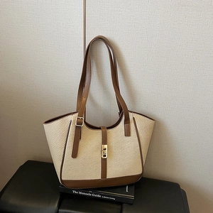 Minimalist woven striped tote bag with contrast leather trim and gold metal buckle detail