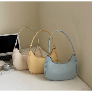 Detailed shot of three crescent shoulder bags in cream, yellow and blue colors
