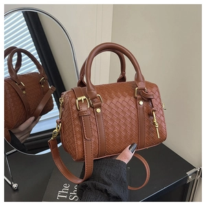 Macro detail of brown woven leather Boston bag featuring gold hardware and twin handles
