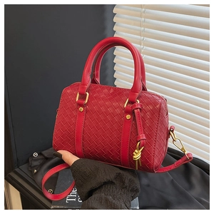 Detail of red woven leather texture and golden hardware with knot zip on handbag