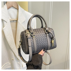 Detail of grey woven texture shoulder bag with golden hardware and decorative knot