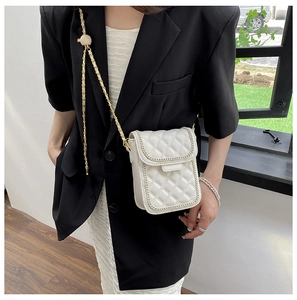 Détails du sac blanc matelassé avec bandoulière en chaîne dorée et coutures fines