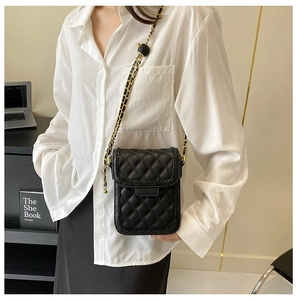 Détail du petit sac matelassé noir avec chaîne dorée et boucle de réglage sphérique