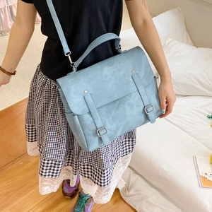 Borsa a tracolla azzurra opaca con fibbie argentate, mostrata a spalla su una modella