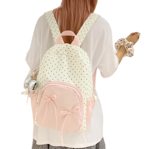 Sweet cream polka dot backpack with pink accents and bows shown from a back view