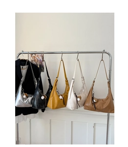 Hobo bags in five colors hanging on a rack with decorative baseball themed pendants