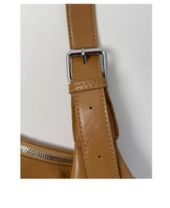 Close-up of brown leather tote bag with silver buckle and fine stitching detail