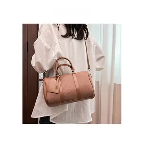 Detail of a vintage brown lychee grain Boston bag with dual handles and shoulder strap