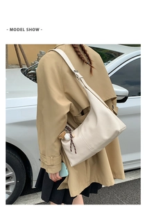 Chic beige hobo bag detail featuring soft faux leather and trendy baseball charm