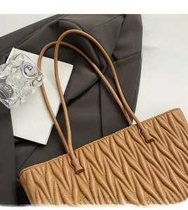 Détail de la texture en cuir matelassé sur le grand sac cabas couleur caramel