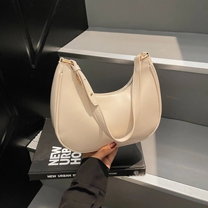 Retro cream white crescent shoulder bag with adjustable strap on urban steps background