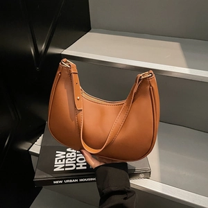 Brown leather crescent shoulder bag with adjustable strap and vintage minimalist design