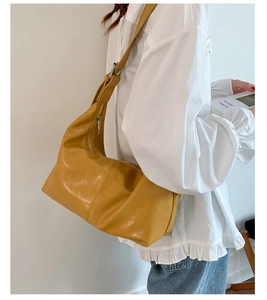 Detailed view of ginger yellow oversized faux leather hobo bag with silver adjustable buckle