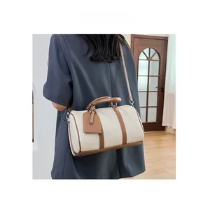 Litchi pattern texture on cream white Boston bag with brown leather piping and strap