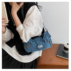 Detail of vintage blue denim shoulder bag with silver metallic buckles and rivets