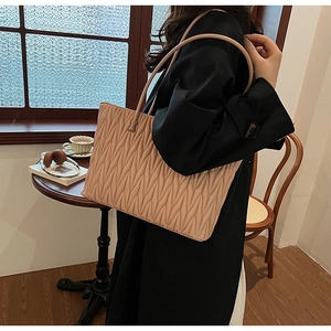 Vue détaillée de la texture plissée du sac cabas beige avec fines bandoulières
