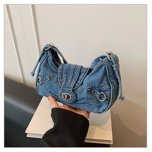 Close-up of vintage blue denim underarm bag with silver rivets and metal turn lock detail