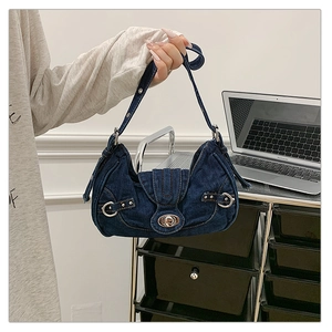 Detail of dark blue denim shoulder bag with silver buckles and Y2K vintage metal hardware