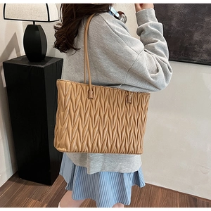 Détail du sac cabas matelassé marron clair avec texture plissée et fines bretelles