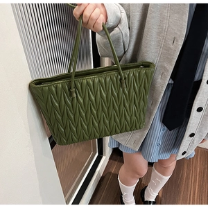 Détail du sac cabas vert avec texture plissée en V et longues bandoulières