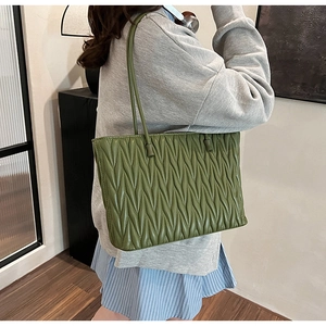 Détail du sac cabas en similicuir vert matelassé avec des bandoulières élégantes