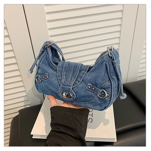 Detail of vintage blue denim shoulder bag with silver turn-lock and Y2K biker style straps