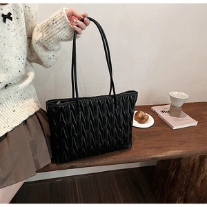 Détail du sac cabas noir matelassé avec texture plissée verticale et doubles lanières