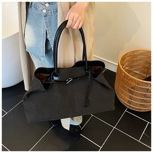 Top view of a black matte tote bag with adjustable straps and deep brown lining details
