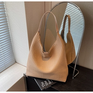 Close-up of woven hobo shoulder bag texture and semi-moon shape in soft beige
