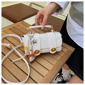 Detailed view of a white leather crossbody bag with yellow dots and cute goose charm