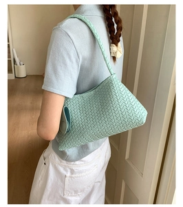 Detailed close-up of mint green woven shoulder bag featuring intricate twill texture