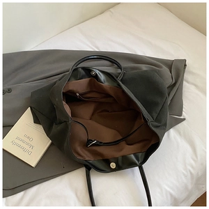 Detailed interior of vintage black tote bag showing magnetic buckle and inner zipper pocket